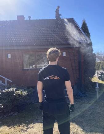 Arbetare från Svea Takvård rengör tak på en villa i Enköping